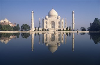 INDIA, Uttar Pradesh, Agra, Taj Mahal at sunrise reflected in pool of water