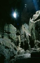 MALAYSIA, Borneo, Niah Caves, View of rocky interior lit by sunlight pouring through small opening