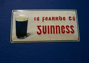 IRELAND, County Galway, Spiddal, Guinness sign written in Gaelic on Pub wall