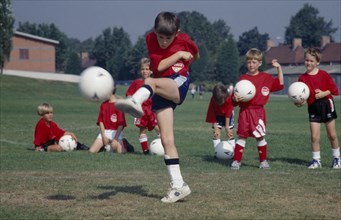 10001961 SPORT Ball Games Football Young boy kicking football during coaching derby.