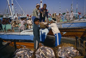 PAKISTAN, Sind, Karachi, Workers unloading fish from boat on docks