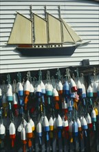 USA, Maine , Boothbay Harbour, Lobster buoys hanging on wall of clapperboard building beneath a