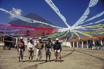 GUATEMALA, Santiago, Charismatic church festival with five local men standing under streamers