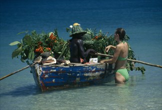 WEST INDIES, St Lucia,  Reduit Beach, Beach vendor selling fruit from boat