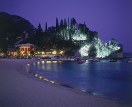 GREECE, Epirus Region, Parga, View along Krioneri Beach to restaurant and rocky headland