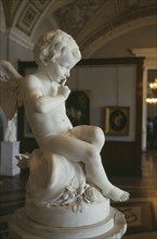 RUSSIA, St Petersburg, "The Hermitage Museum, interior of a gallery, cherub statue in foreground"