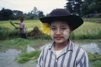 20003942 THAILAND Tak Province  Mae Sot Karen girl with painted facial markings  rice paddy in background