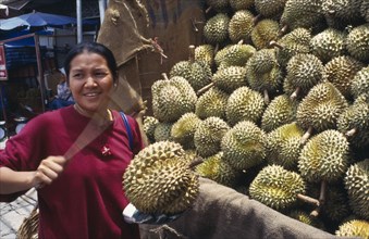 THAILAND, Chiang Mai, Warorot, Woman tests durian fruit in market