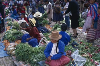 PERU, Cusco Department, Pisac, Vegetable stalls on the ground in cobbled a market place. Crowds of