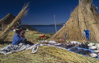 PERU, Puno Administrative Divsion, Lake Titicaca , "Woman and child seated outside a reed house on