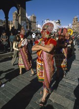 PERU, Cusco Department, Cusco, Street parade of men in traditional costume and head dress at Inti