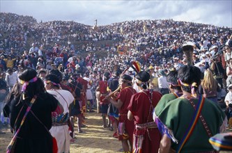 PERU, Cusco, Parade of musicians at Inti Raymi watched by crowds on the surrounding hillside.