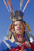 PERU, Cusco, Male figure in traditional costume and feathered headress at Inti Raymi.  Head and
