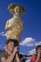 PERU, Cusco Department, Cusco, Young men carrying a golden Inca statue at Inti Raymi.