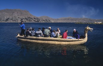 PERU, Puno Administrative Department, Puno, Lake Titicaca.  Tourists on a reed boat on the lake.