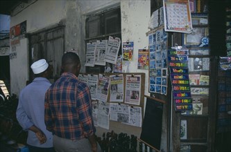 TANZANIA, Zanzibar, Stone Town.  Two men at a newspaper stall.