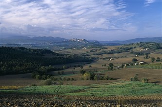 ITALY, Umbria, Todi, View across fields and hillside towards the hilltown of Todi.