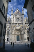 ITALY, Umbria, Orvieto, The Duomo facade partly viewed through a narrow street.