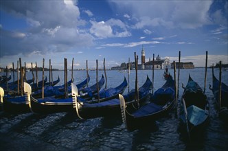 ITALY, Veneto, Venice, Line of gondolas with the Church of San Giorgio behind.