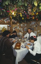 SOCIETY, Religion, Judaism, England.  Jewish family eating a meal in a Sukka during the Sukkot