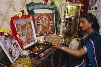 SOCIETY, Religion, Hinduism, England.  Girl lighting candles at home during Dirwali.