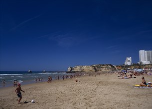 PORTUGAL, Algarve, Praia da Rocha, View along beach with children playing beach soccer