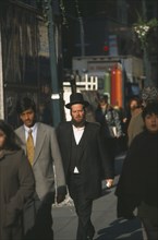 USA, New York State, New York, Orthodox Jewish man walking among other people on 47th Street.