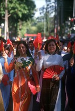 VIETNAM, Ho Chi Minh City, Young women holding flags and fans on the 25th Anniversary Parade for