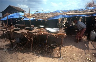 CAMBODIA, Kompong Thom, Phnom Prasat refugee camp.  Refugees in makeshift shelter with table and
