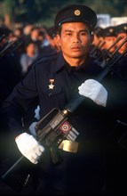 LAOS, Military, Electricity worker in militia uniform on parade carrying a USM M16 machine gun.