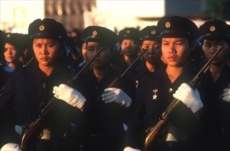 LAOS, Military, Air Lao workers in militia uniform at the Fifth Anniversary Parade carrying rifles.