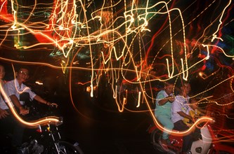 VIETNAM, Ho Chi Minh City, Motor cycle riders on the evening of Liberation Day and coloured light