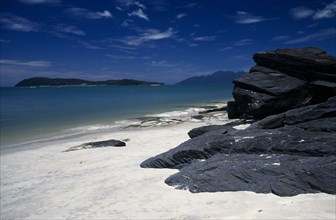 MALAYSIA, Kedah, Langkawi, Pantai Tengah beach looking towards Pulau Rebak Besar island with rocks