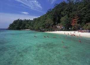 MALAYSIA, Kedah, Langkawi, Pulau Paya marine national park tree lined beach with tourists snorkling