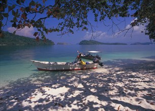 MALAYSIA, Kedah, Langkawi, Pulau Singa Besar wildlife reserve island with men unloading long boats