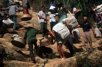 VIETNAM, Work, Smuggling on the border with China.  Porters carrying baskets of goods up a steep