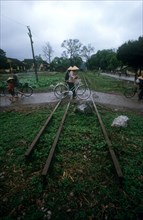VIETNAM, Lang Son, People with bicycles crossing a disused railtrack near the Chinese border.