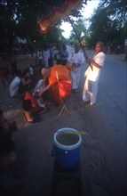 CAMBODIA, Saang, Buddhist monk blessing a child at the roadside.