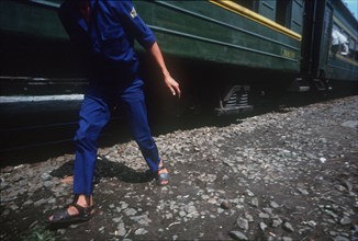 VIETNAM, Danang, Cropped shot of a figure walking alongside green train carriage.