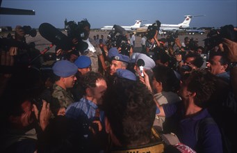 CAMBODIA, Phnom Pehn, Crowds of press clustering around UN soldiers as they arrive at the airport.