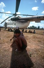 CAMBODIA, Genera, Politics, Young boys crouching in the shade cast by the blades of a UN helicopter