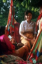 VIETNAM, Market, Woman selling brightly coloured fabrics and cloth.