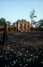 VIETNAM, Hue, Minh Mang Tomb.  View across courtyard scattered with flowers towards ruins with