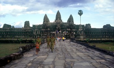 CAMBODIA, Siem Reap, Angkor Wat, "View along wide stone path towards temples and visitors, small