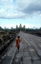 CAMBODIA, Siem Reap, Angkor Wat, Small boy on the stone path leading to the temples which stand