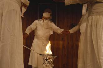 SOCIETY, Religion, Zoroastrian, Parsis encircling fire in a temple.  Flames burn eternally in their