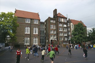 ENGLAND, London, Islington, Victorian Junior School with young children in the playground.