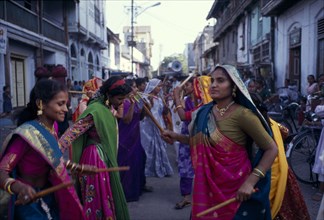 INDIA, Gujarat, Bhavnagar, Hindu wedding with women doing a traditional dance with sticks in the