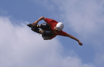 20011106 SPORT Skate Boarding Stunts Skate boader twisting in mid air  blue sky behind.