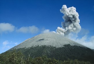 INDONESIA, Java, Mount Semeru, Smoke rising from the volcano as it erupts above the tree lined base
